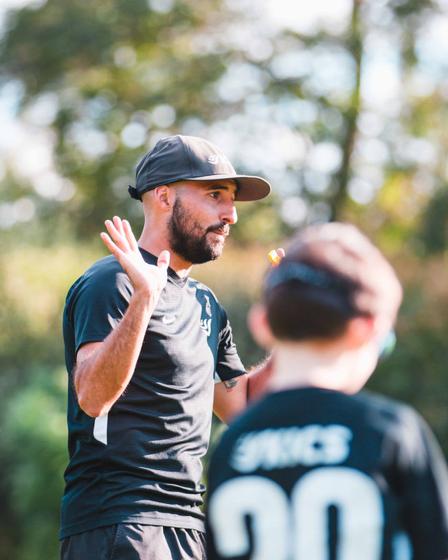 Coach Reinaldo Larotta teaching kids how to play soccer