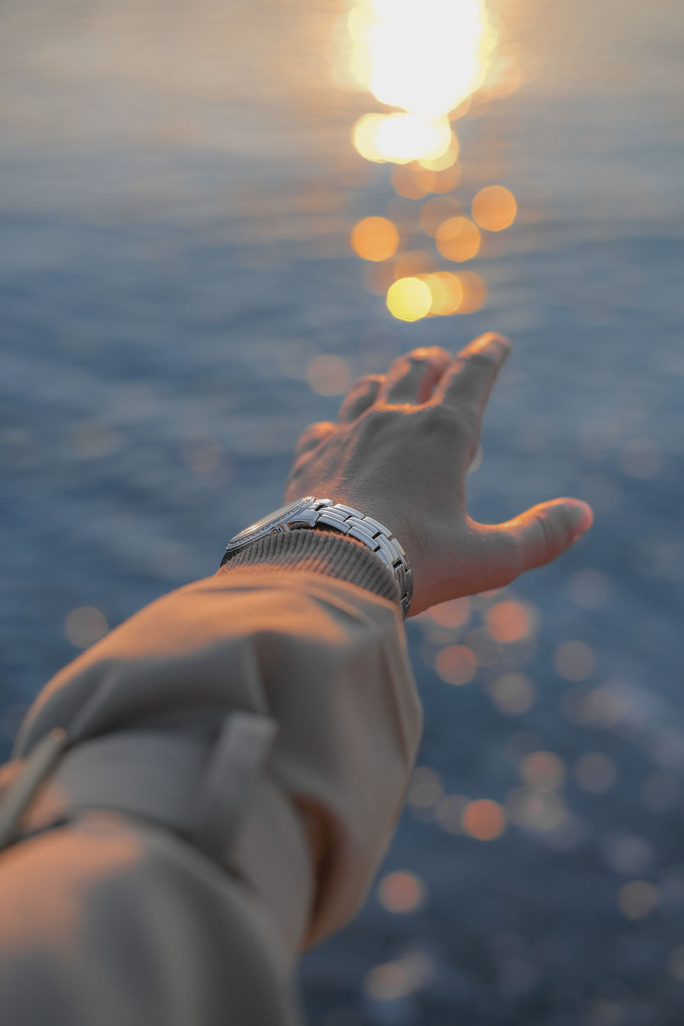 A hand reaching out over the water