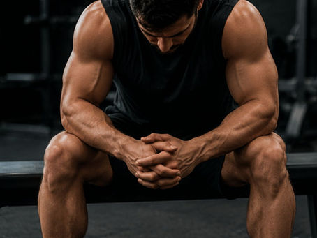 Un atleta en un gimnasio oscuro y realista muestra dos momentos clave del entrenamiento: en la parte superior ejecuta un peso muerto pesado con máxima intensidad, y en la parte inferior aparece sentado en un banco en estado de fatiga y recuperación. La imagen representa el contraste entre esfuerzo máximo y la necesidad de descanso estratégico para el rendimiento.