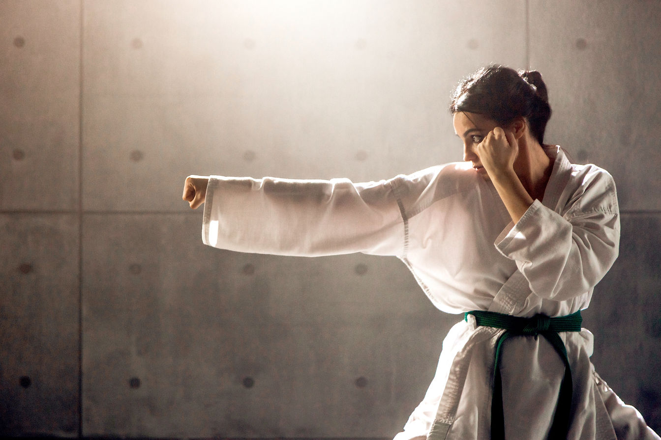 Karate woman in stance, green belt