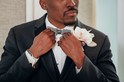Groom Adjusting Bow Tie Before Wedding Ceremony