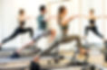 Class in a gym doing pilates standing lu