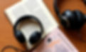 Open book with headphones representing Catholic and Christian podcasts for mental health and literary reflection.