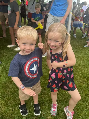 Smiling boy and girl showing off glitter tattoos at WaunaBoom