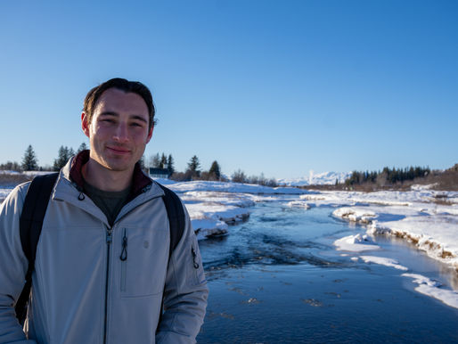 Collin in Iceland in front of a river with snow covered banks