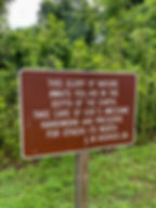 Brown sign with a quote about protecting nature at Florida Caverns State Park.