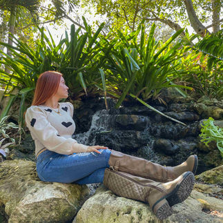 woman sitting in front of rock waterfall