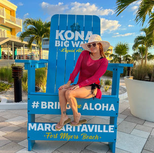woman sitting on giant blue chair and posing for photo