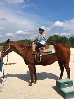 girl posing and riding horse