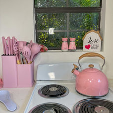 Kitchen window with pink salt and pepper shakers and tropical view.