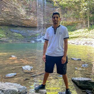 Person standing near a waterfall pool at Cloudland Canyon State Park.
