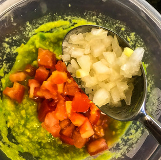 adding onions to guacamole