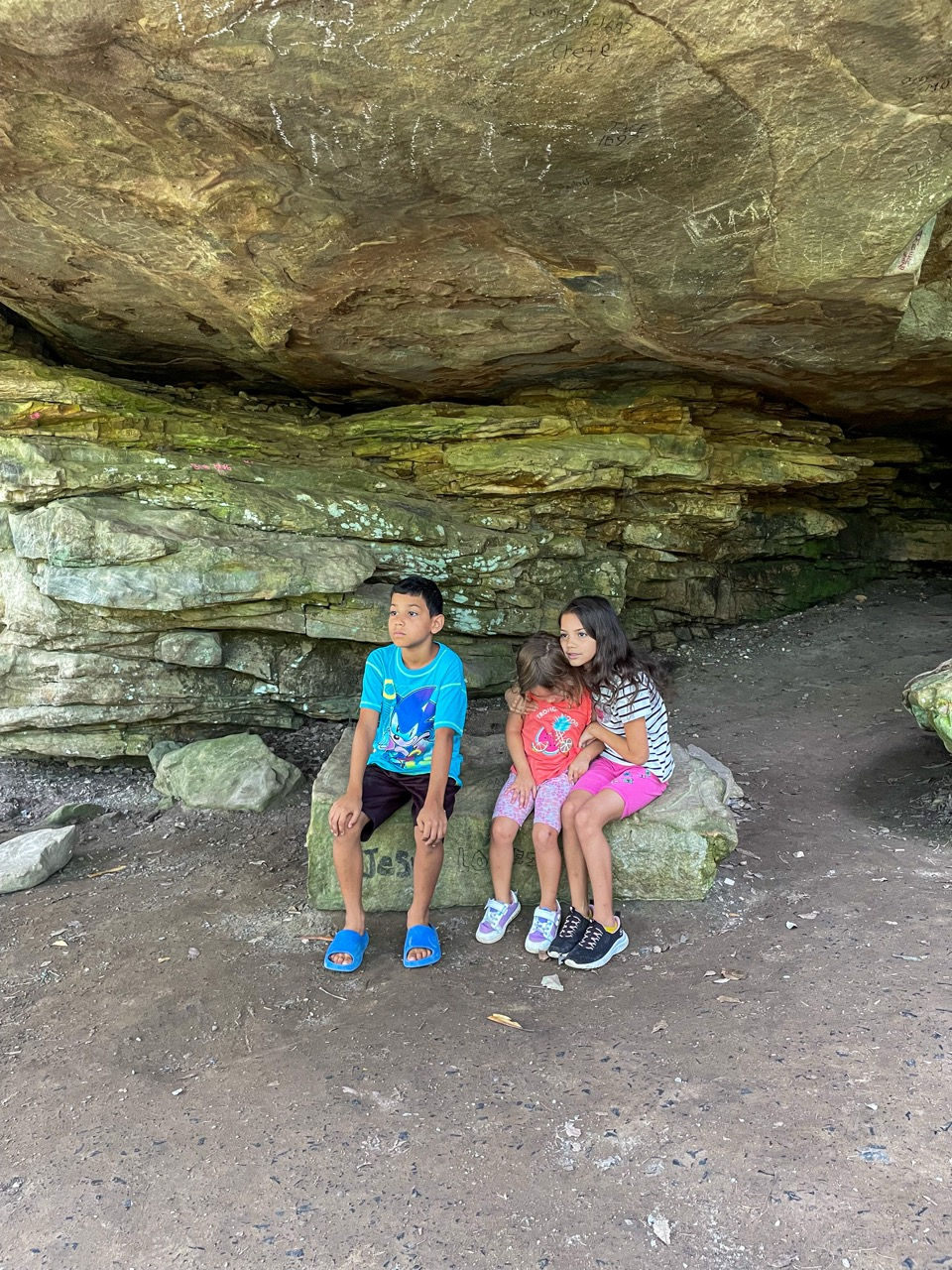 Children sitting inside a shaded rock shelter at Cloudland Canyon State Park. 