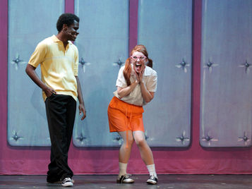 Two actors in MSTC's production of "Hairspray" performing on stage.