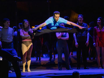 Performer doing a split jump on stage.