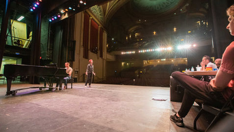 Photo of the stage at the State Theatre taken from the back of the stage, looking out into the audience seats.