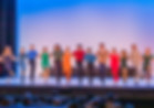 MSTC members form a kick-line on stage.