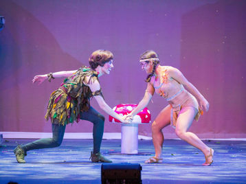 Two performers dance on stage in "Peter Pan" the musical.