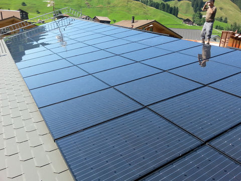 Auf Dachschiefer aufgebaute Photovoltaikmodule auf einem Mehrfamilienhaus.