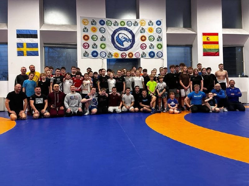 Спортсмени і тренери клубу разом на килимі після змагань