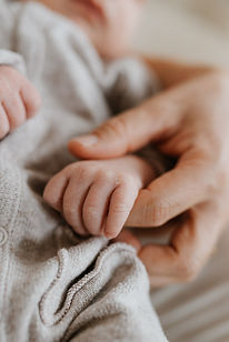 Baby holds mom hands
