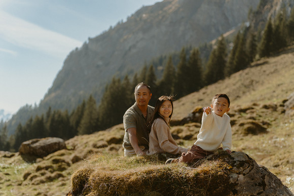 Family holding hands and enjoying panoramic mountain views during a Mt. Pilatus photoshoot
