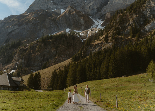Family walking through an alpine meadow during a Mt. Pilatus family photoshoot in Lucerne, Switzerland