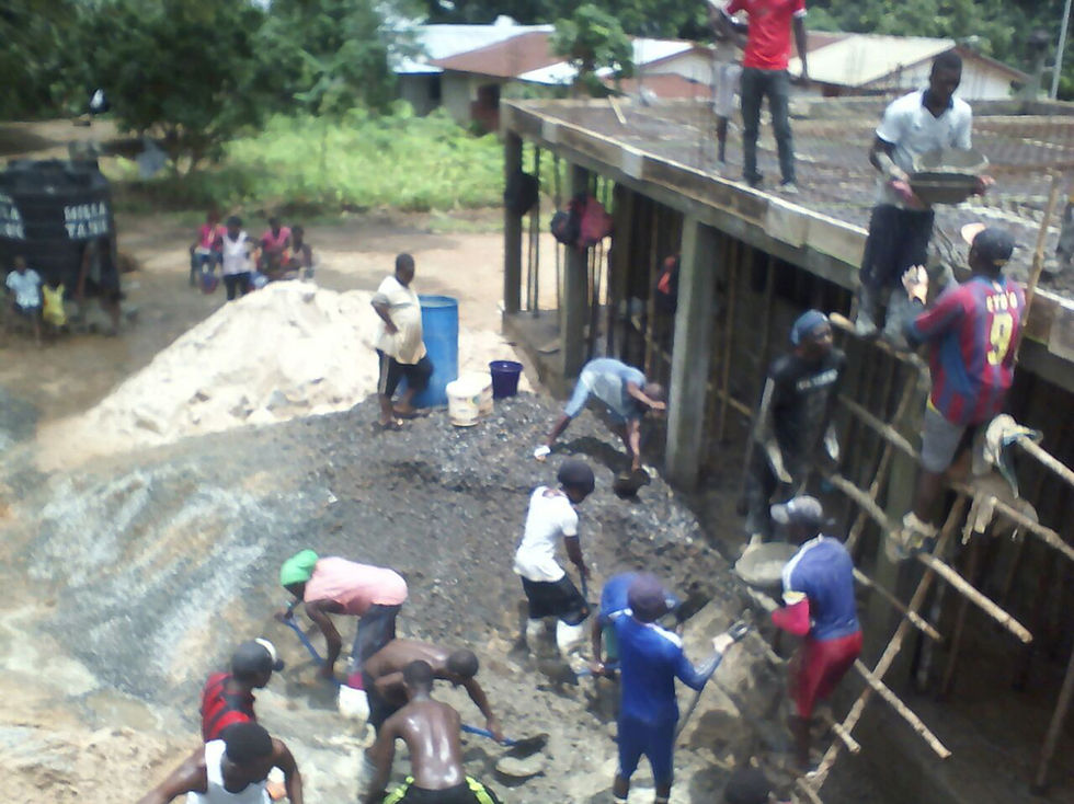 Community volunteers carry cement up to the second floor