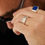 Thumbnail: Sterling silver engraved band ring with leaf pattern resting on wood surface.