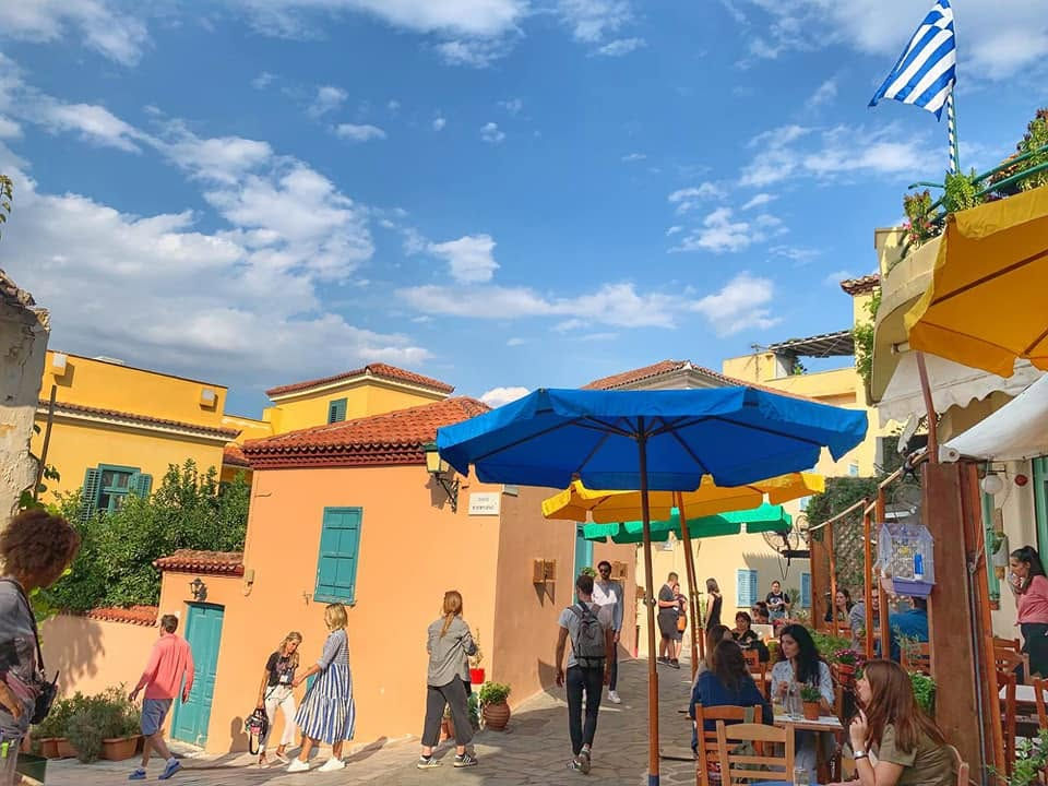 People at an outdoor cafe with Greece travel recommendations.