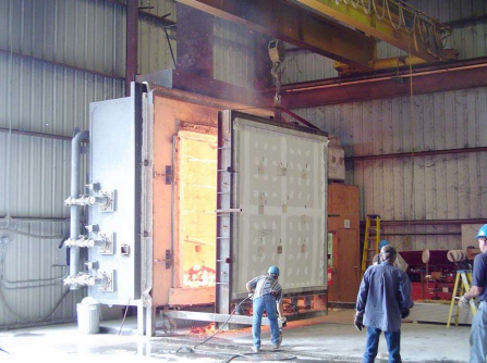 man pulls Agriboard panel from fire test furnace