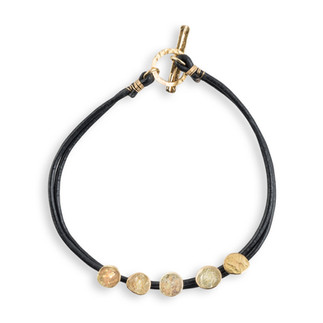 black leather in a circular shape with five gold hammered diks and gold toggle.