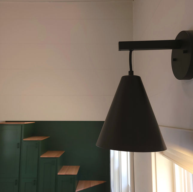 Modern tiny home. Black sconce light. Tiny house stairs.