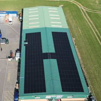 A big factory with solar panels in the shape of the letter H