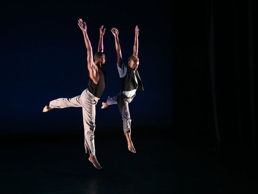 two dancers leaping with arms up