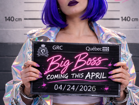 A person with purple hair holds a sign reading "Big Boss Coming This April 04/24/2026" in front of a height chart, wearing a holographic coat.