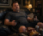 A fat guy drinking beer alone with a video game controller in his hand. Demonstrating how vices limit your life.