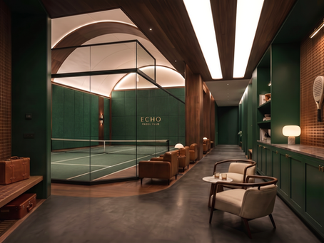 Premium indoor padel club interior with racket display wall, dark tiled backdrop and hospitality lounge seating