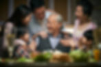 Asian family lovingly surrounding their father at his birthday
