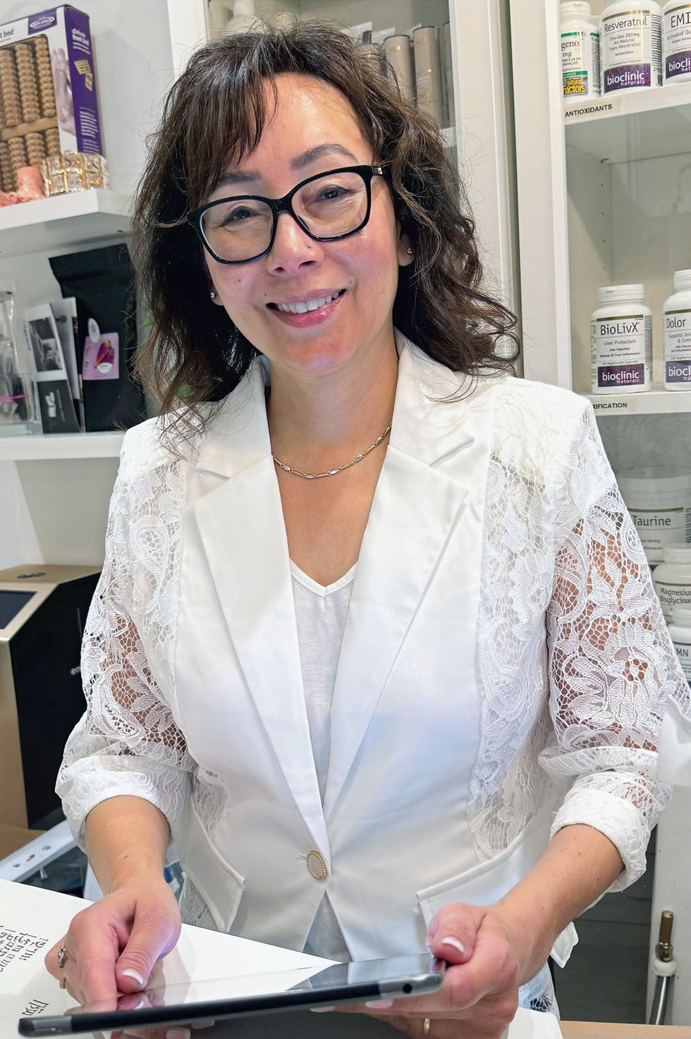 Liza James, Licensed Esthetician and owner of Cantik Esthetics Skin Care in Surrey, BC, seated at her professional skincare clinic desk
