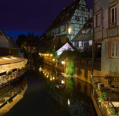 Abendliches Elsaß mit beleuchteten Häusern am Kanal