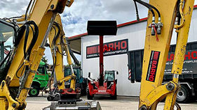 Gelber Bagger Komatsu BARHO Baufahrzeuge, vor einem BARHO-Gebäude, HOME.