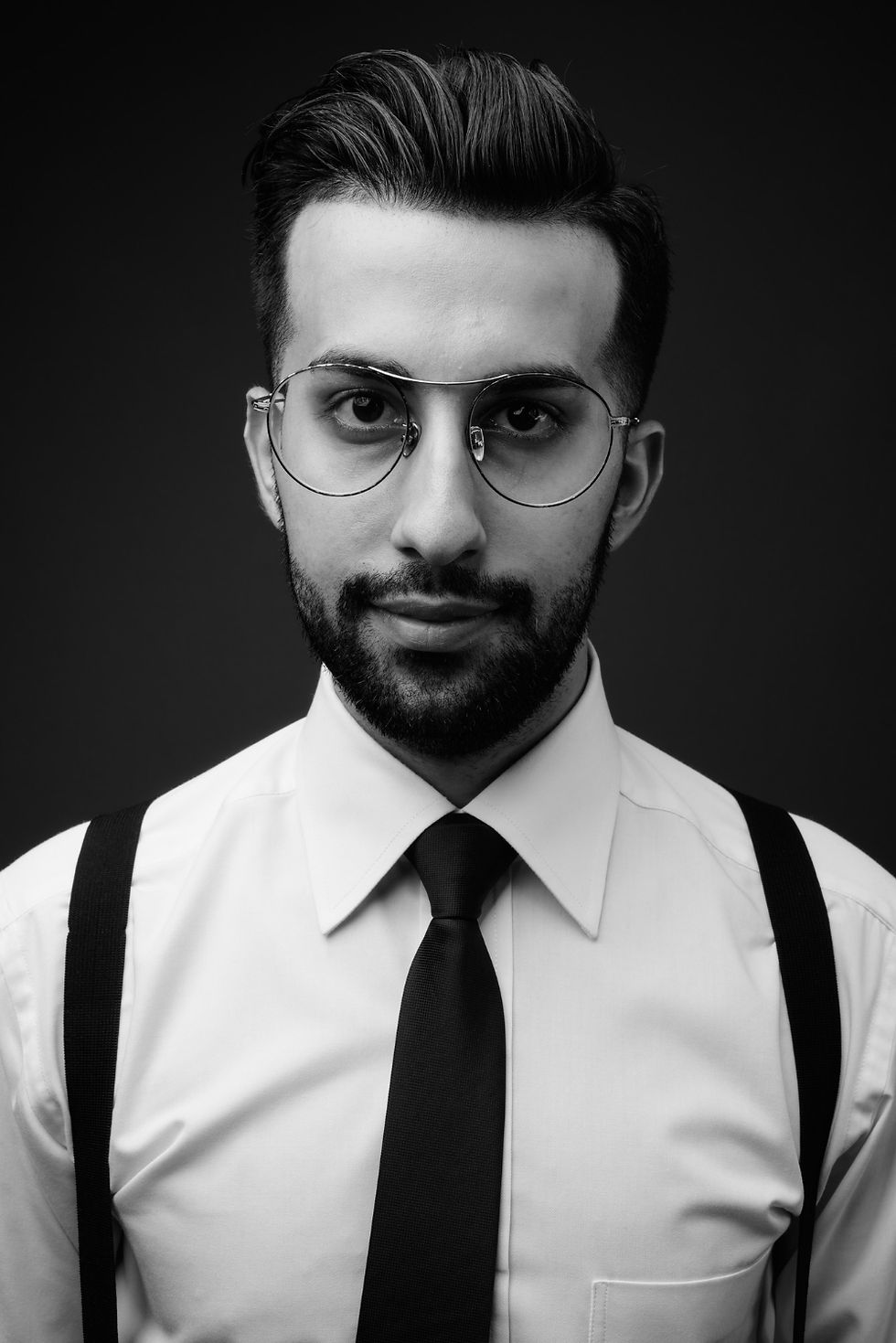 Man with glasses, beard, white shirt, tie, and suspenders