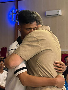 Sau khi chia sẻ, tôi có lời kêu gọi mọi người bước lên nếu ai đó mong muốn cảm nhận một cái ôm ấm áp và cầu nguyện. Và rồi có những hàng dài trong vài tiếng đồng hồ. Khi kết thúc, một chàng trai trẻ tiến về phía tôi, ôm chầm lấy cổ tôi. Bạn ấy tựa vào vai tôi và nói: “CON CẦN MỘT CÁI ÔM.” Hai giây ngừng lại, bạn ấy tiếp tục: “BỐ MẸ CON VỪA MỚI CHIA TAY.” Chính là nó. Nỗi đau thầm kín, thường là sự xấu hổ đẫm máu của một gia đình tan vỡ. Nhưng bạn biết không: Chúng tôi đã tìm ra phương thuốc hiệu quả cho nỗi đau như vậy. Tôi đã chứng kiến điều đó rất nhiều lần. Phương thuốc này không phải là thuốc men hay thuốc kích thích. Trước hết và trên hết, đó là sự thật. Sự thật được nói ra. Giống như cậu bé này, đơn giản đã nói ra nỗi lòng của mình: “Con cần một cái ôm. Bố mẹ con vừa chia tay.”