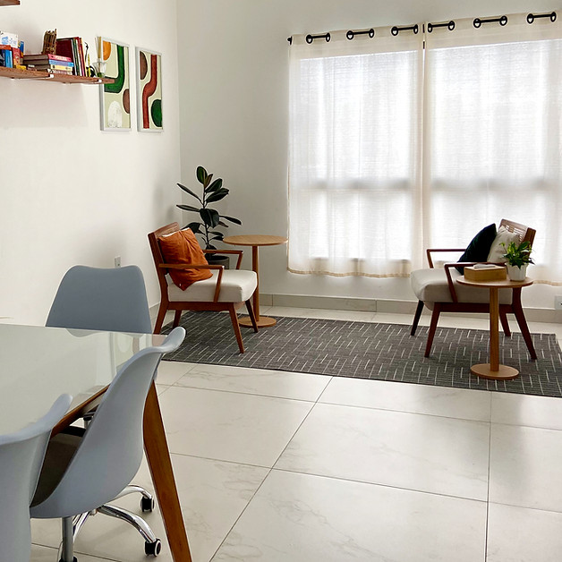 Ambiente acolhedor da clínica de psicologia, com móveis confortáveis, decoração minimalista e iluminação natural para atendimento psicoterapeutico.