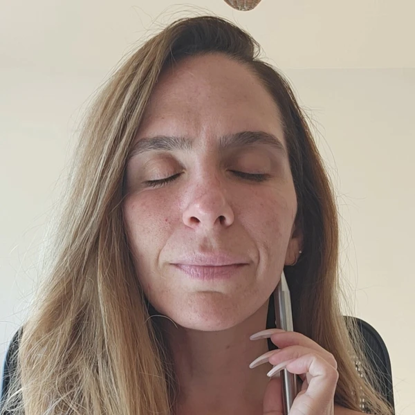 Woman with eyes closed gently applying a reflexology pen to her jawline, practicing a calming technique from Sanadora’s Anxiety Workshop