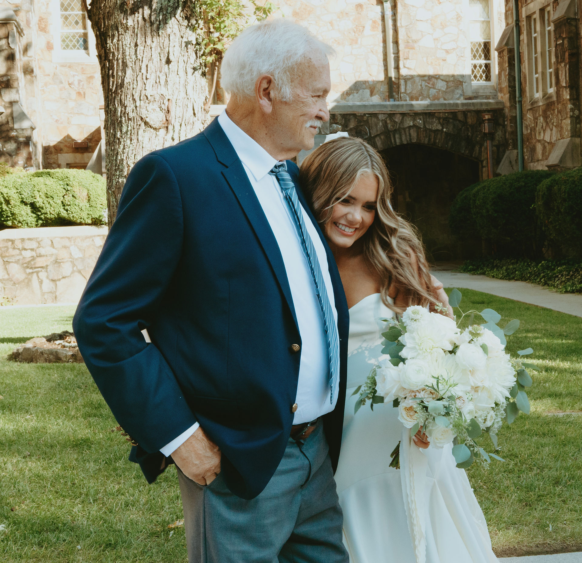 Bride walking with her grandparent while holding her bouquet during the wedding day.