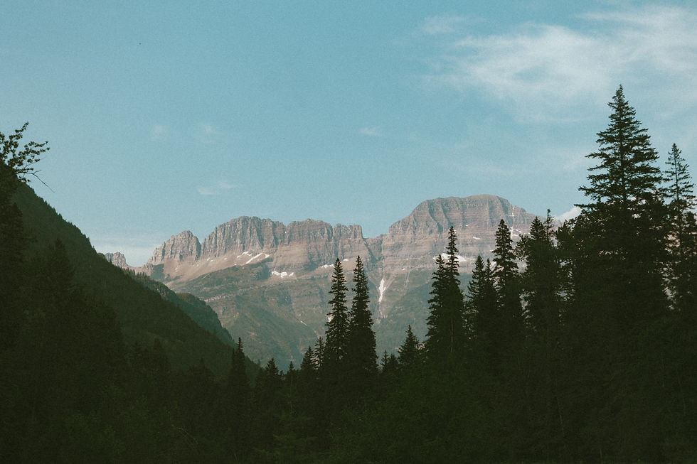 Mountain range with snow patches under a clear blue sky, captured during a Glacier National Park elopement
