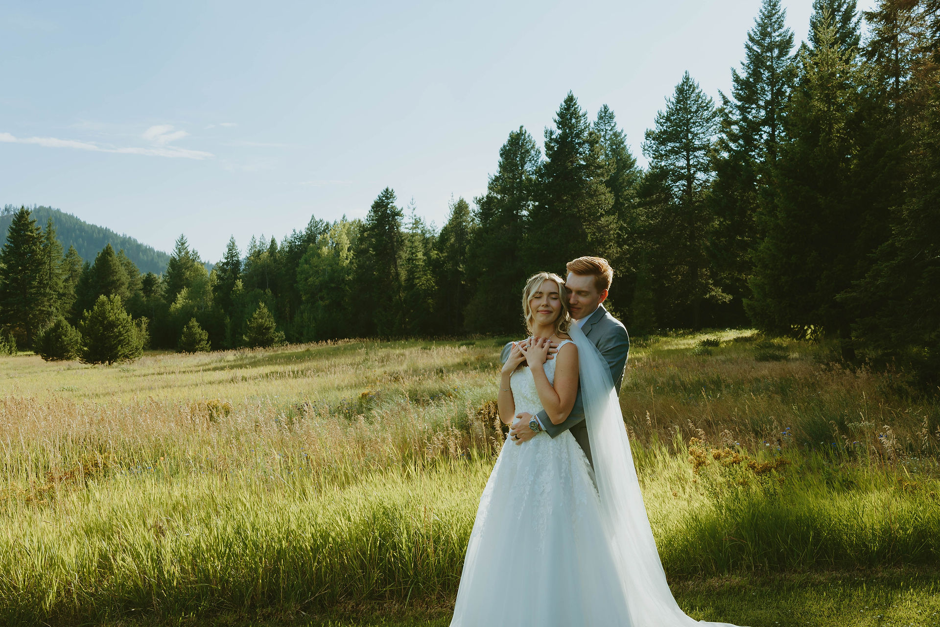 Bride and groom standing together during relaxed wedding portraits in a natural outdoor setting