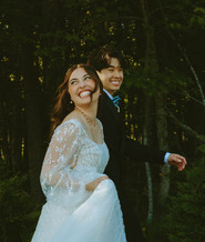 Bride laughing while walking with her partner during wedding portraits, captured in a natural documentary style
